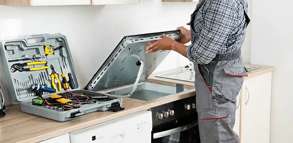 Handyman repairing a cooktop and checking wiring connections in Spokane, WA