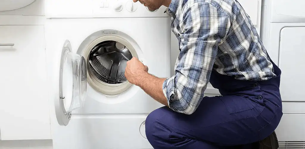 Handyman inspecting a dryer drum and internal parts for repair in Spokane, WA