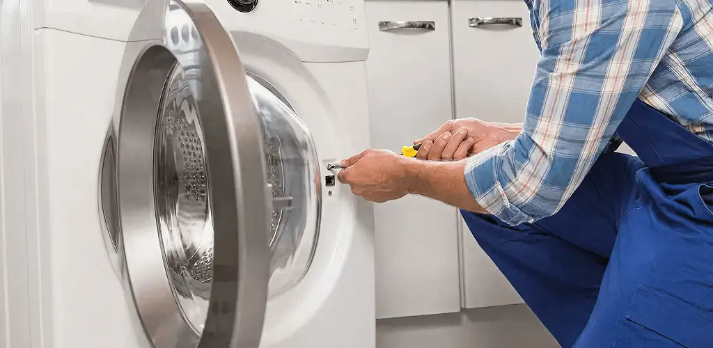 Handyman repairing a clothes dryer and checking electrical connections in Spokane, WA