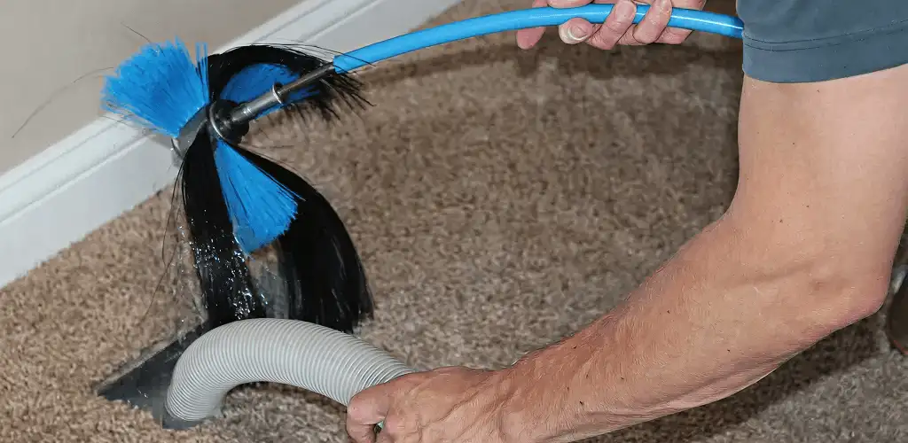 Dryer vent cleaning technician brushing lint from a vent line in Spokane, WA