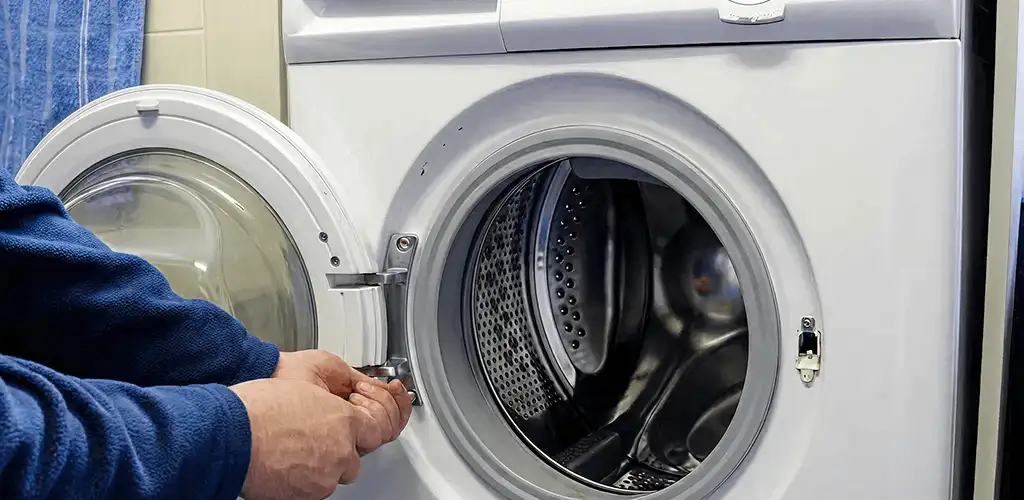 Washing machine repair handyman checking a front-load washer door and latch in Spokane, WA