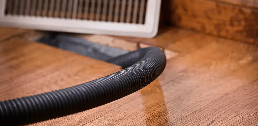 Air duct cleaning hose inserted into a floor vent for ductwork cleaning in Spokane, WA